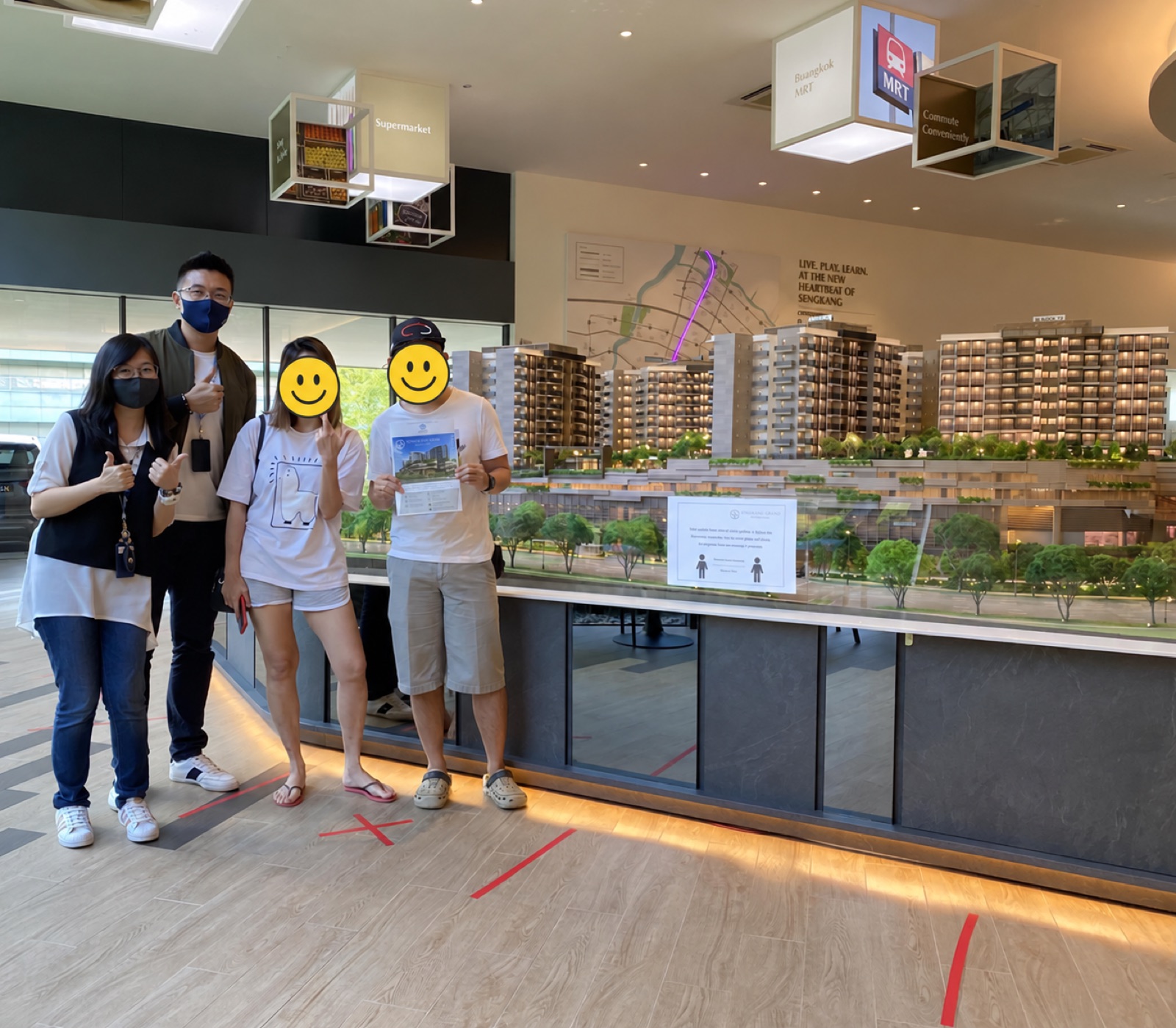 Stevenson and Celine at a property showroom with clients whose faces are covered for privacy